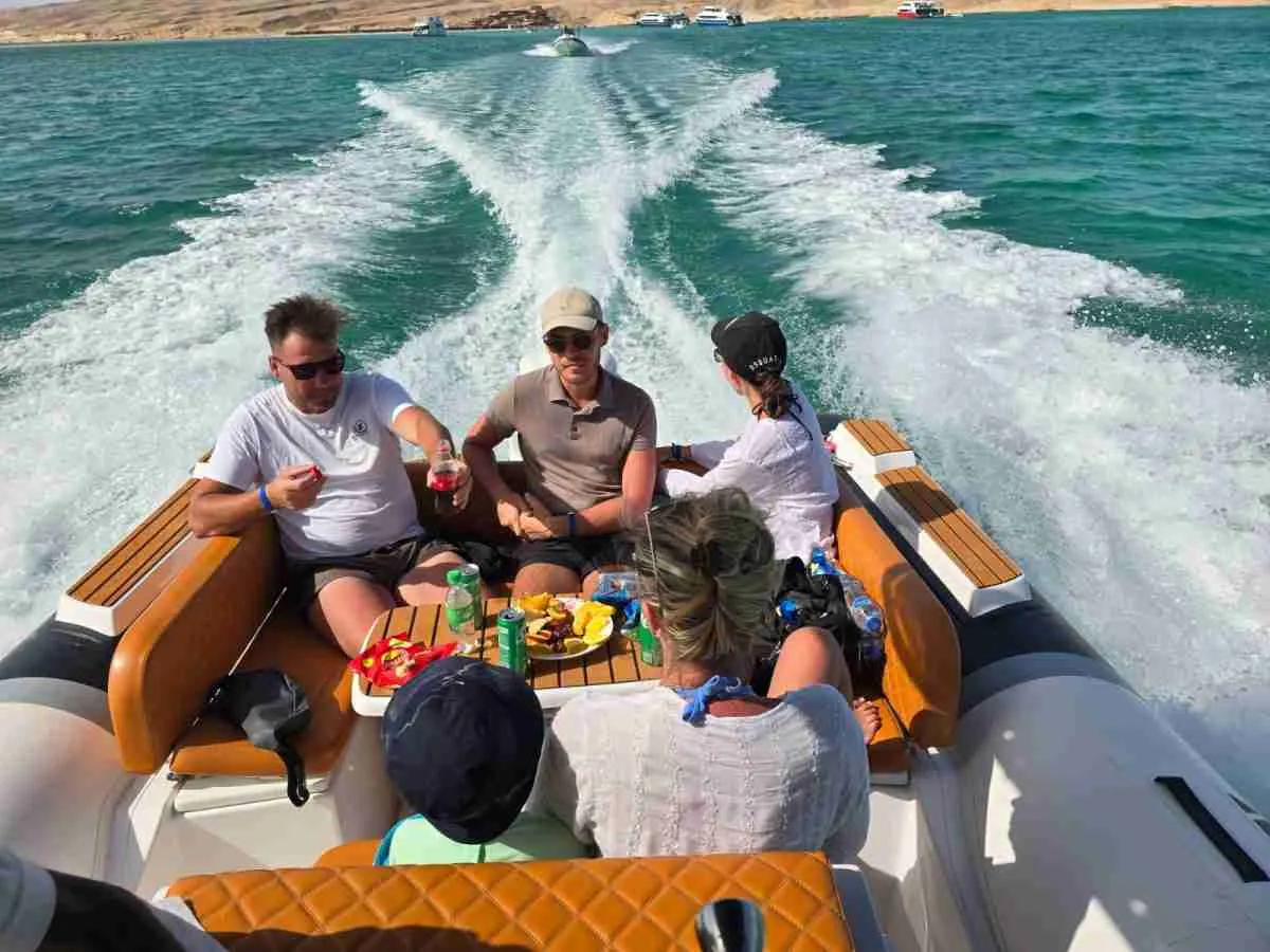 Speed boat Hurghada tour with dolphins in the Red Sea and tourists enjoying a fast boat adventure in Egypt.